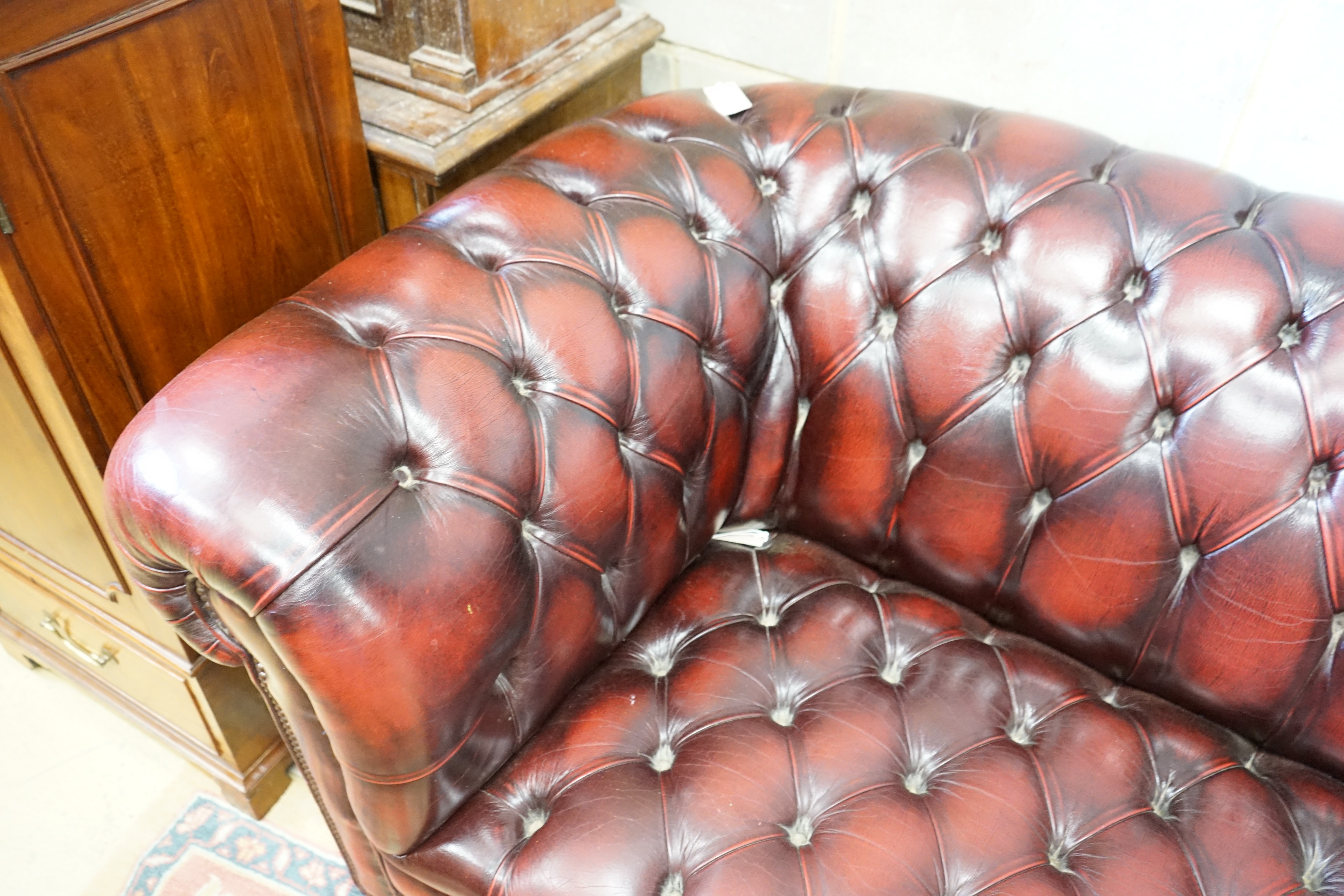 A Victorian style buttoned burgundy leather Chesterfield settee, length 200cm, width 90cm, height 74cm